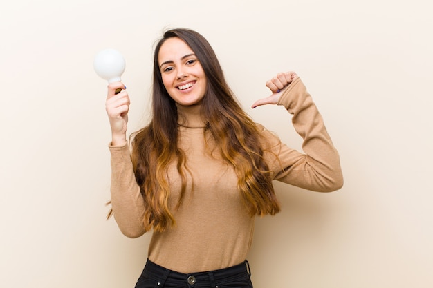 Jeune jolie femme avec ampoule, ayant une idée