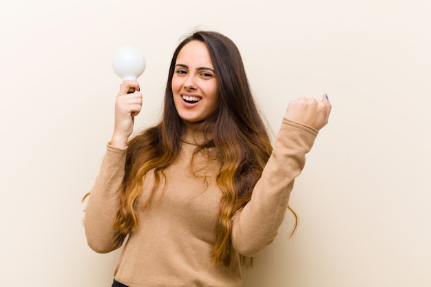 Jeune jolie femme avec ampoule, ayant une idée