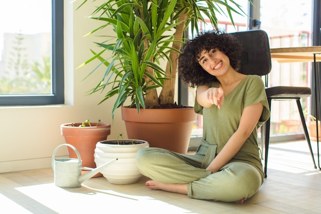 Jeune jolie femme avec un arrosoir et des plantes