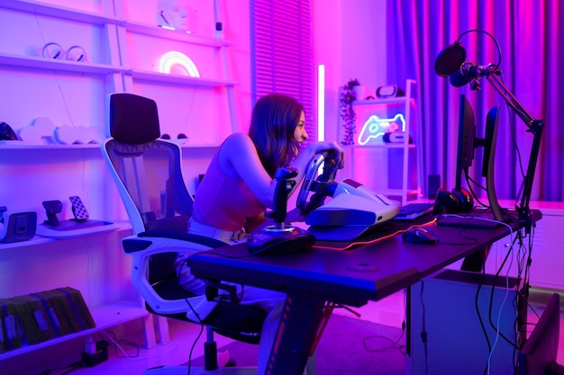 La jeune jolie femme asiatique Pro Gamer diffuse en direct le jeu vidéo Jeu de course à la maison