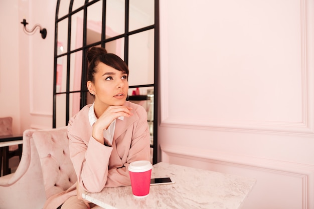 Jeune jolie femme assise au café