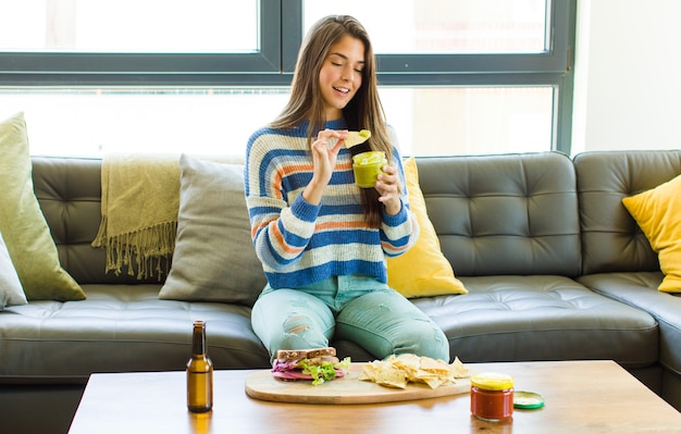 Jeune jolie femme assise sur un canapé en cuir de manger