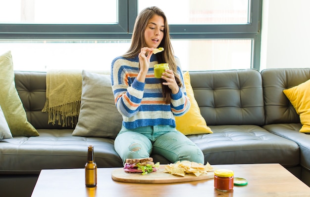 Jeune jolie femme assise sur un canapé en cuir de manger