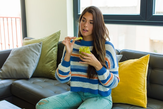 Jeune jolie femme assise sur un canapé en cuir de manger