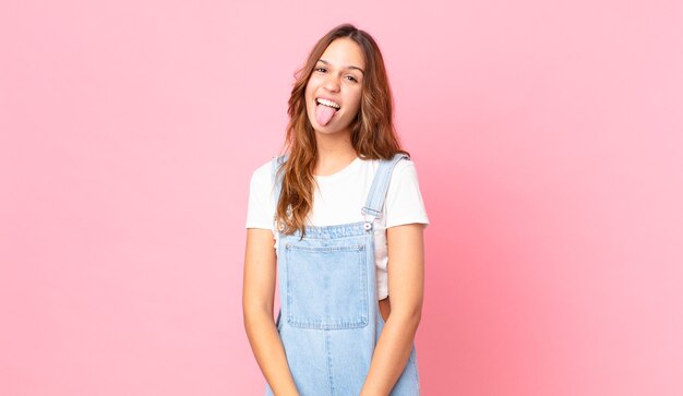 Jeune jolie femme avec une attitude joyeuse et rebelle, plaisantant et tirant la langue