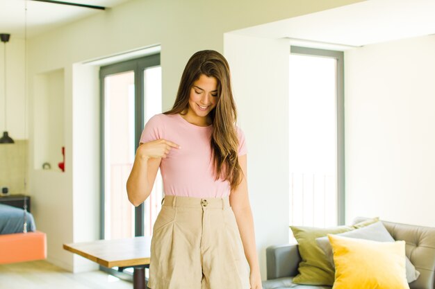 Jeune jolie femme aux cheveux longs à l'intérieur