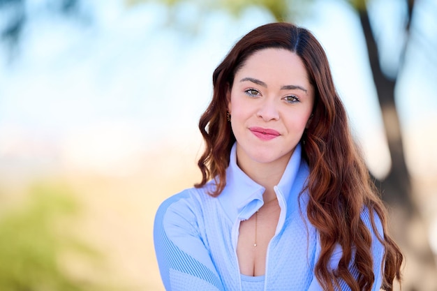 Jeune jolie femme aux yeux verts en robe bleue assise dans le parc de la ville