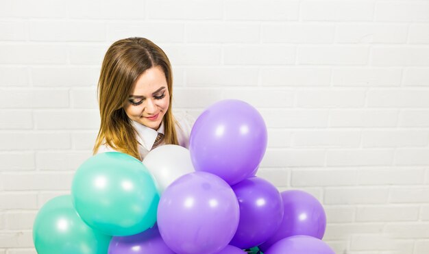 Jeune jolie femme avec des ballons colorés