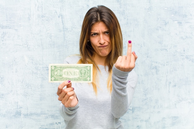 Jeune jolie femme avec des billets contre le mur de grunge