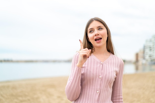 Jeune jolie femme blonde ayant l'intention de réaliser la solution tout en levant un doigt