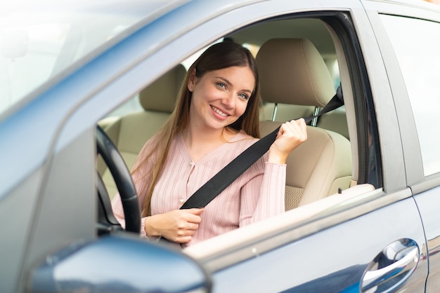 Jeune jolie femme blonde à l'intérieur d'une voiture