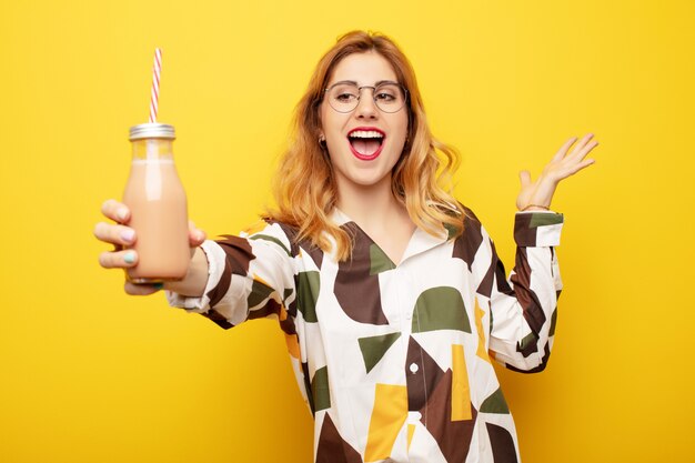 Jeune jolie femme blonde avec un milk-shake