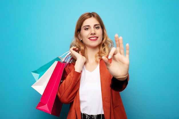 Jeune jolie femme blonde avec des sacs à provisions