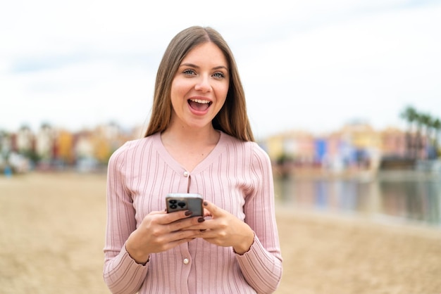 Jeune jolie femme blonde surprise et envoyant un message