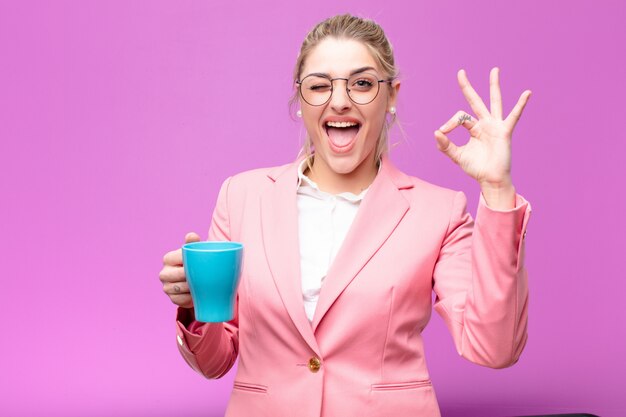 Jeune jolie femme blonde avec une tasse de café