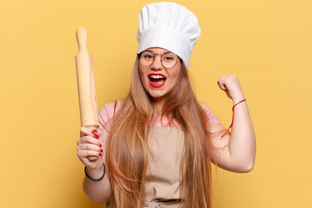 Jeune jolie femme boulanger avec rouleau à pâtisserie