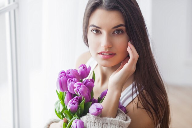 Jeune jolie femme avec bouquet de fleurs