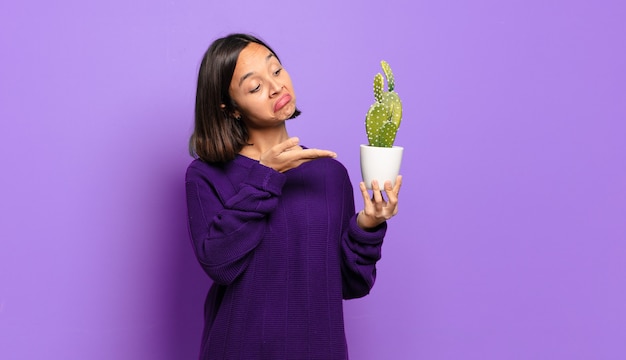 Jeune jolie femme avec un cactus