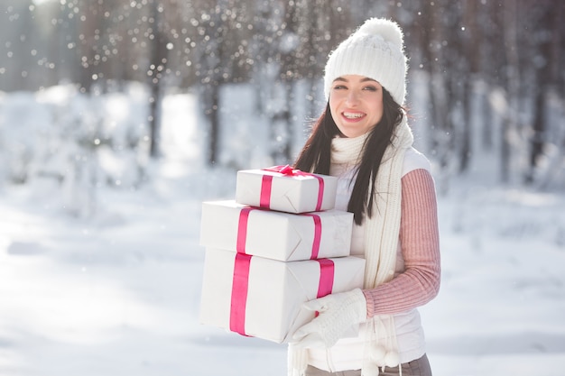 Jeune jolie femme avec des cadeaux de Noël