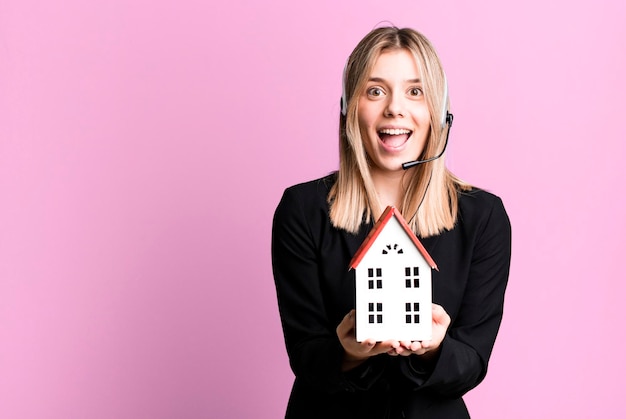 Jeune jolie femme avec casque et un concept d'état réel de modèle de maison