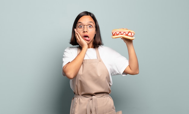 Jeune jolie femme chef avec hot-dog