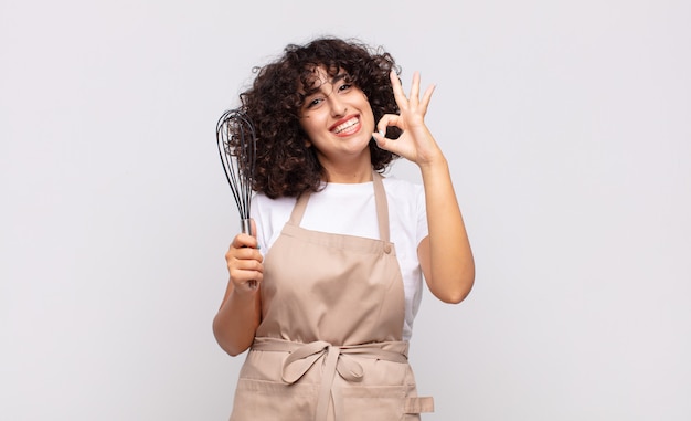 Jeune jolie femme chef portant un tablier