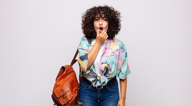 jeune jolie femme avec une chemise colorée et un sac à dos