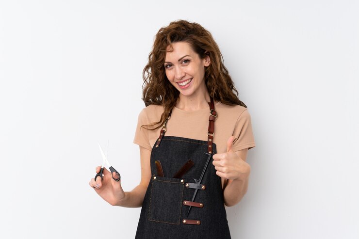 Photo jeune jolie femme avec un coiffeur ou un coiffeur s'habille avec le pouce vers le haut
