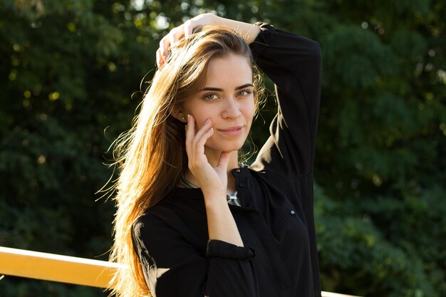 Jeune jolie femme en collier d'argent et vomir ses longs cheveux châtains de lumière du soleil