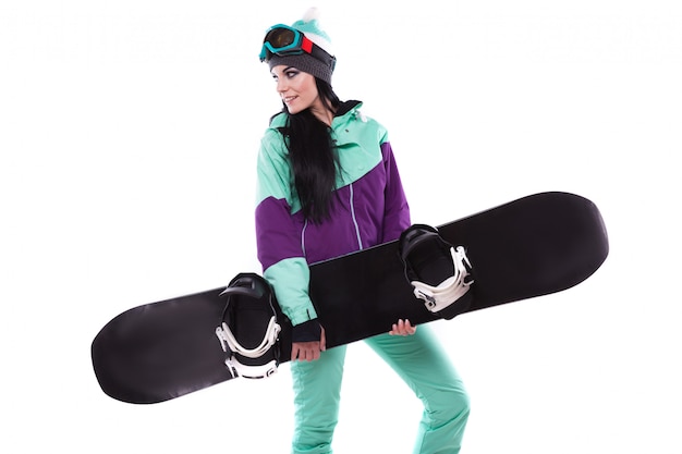 Jeune jolie femme en combinaison de ski pourpre tenir snowboard