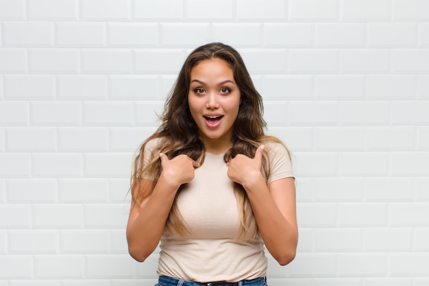 jeune jolie femme contre le mur blanc