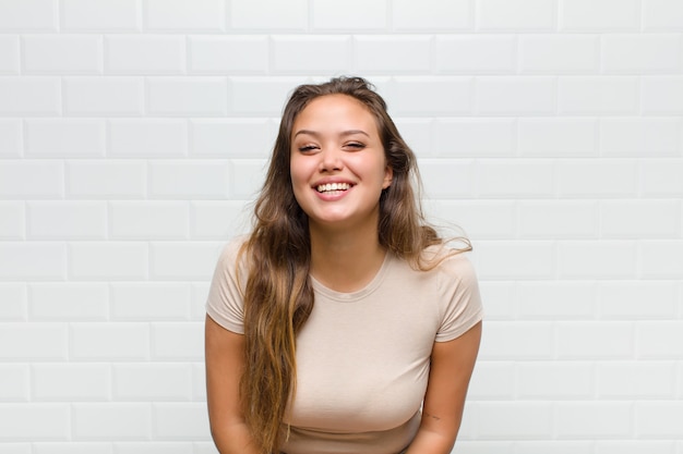 jeune jolie femme contre le mur blanc