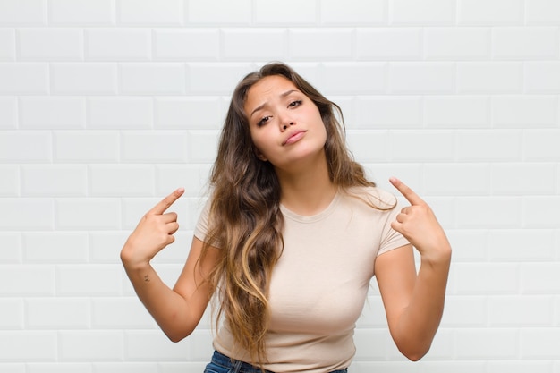 jeune jolie femme contre le mur blanc