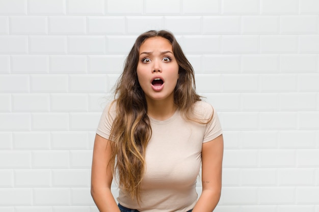 jeune jolie femme contre le mur blanc