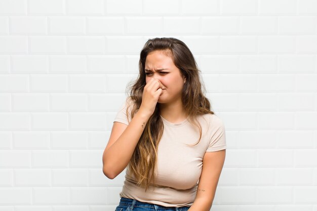 jeune jolie femme contre le mur blanc