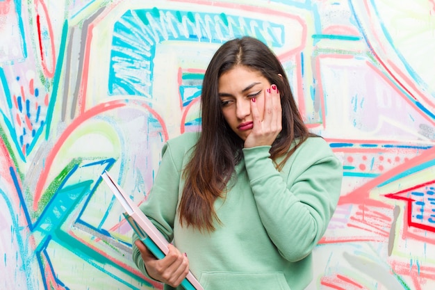 Jeune jolie femme contre le mur de graffitis