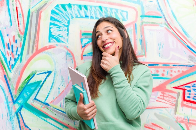 Jeune jolie femme contre le mur de graffitis