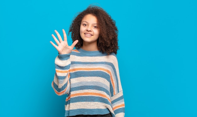 Jeune jolie femme contre un mur isolé