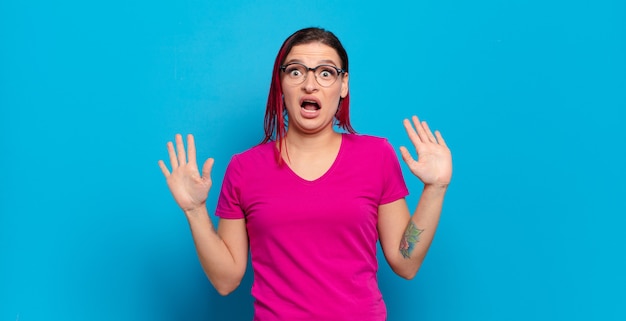 Jeune jolie femme contre un mur isolé