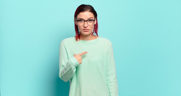 Jeune jolie femme contre un mur isolé