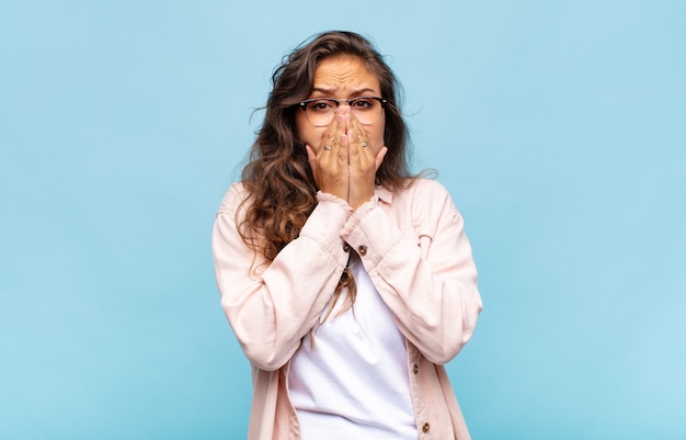 Jeune jolie femme contre un mur isolé