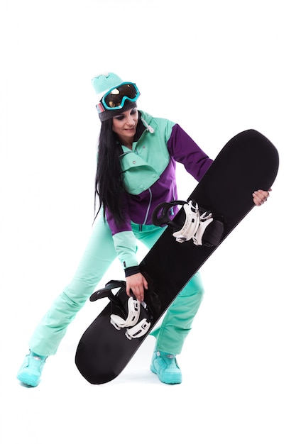 Jeune jolie femme en costume de ski violet tenir snowboard