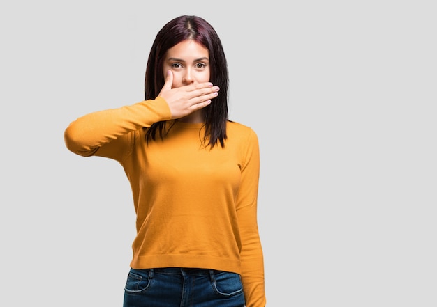 Jeune jolie femme couvrant la bouche, symbole du silence et de la répression, essayant de ne rien dire