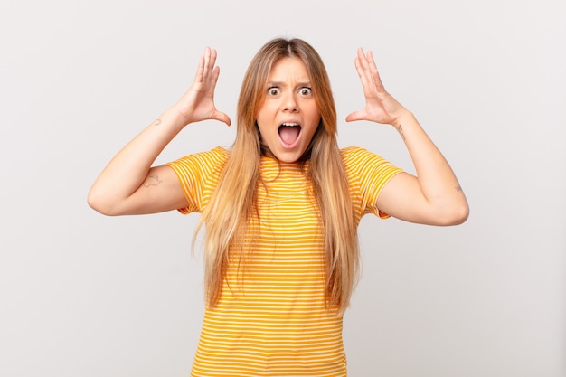 Jeune jolie femme criant avec les mains en l'air