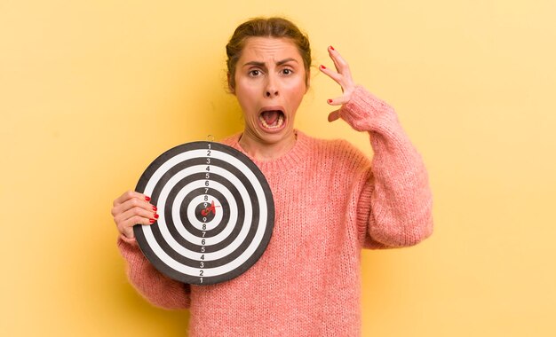 Jeune jolie femme criant avec les mains dans le concept de cible de fléchettes d'air