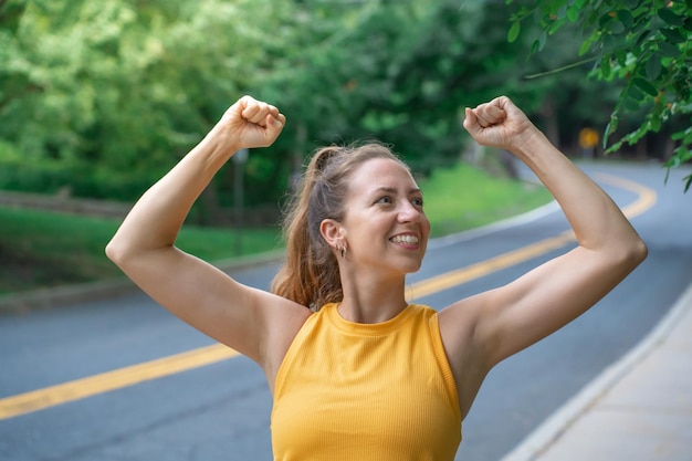 Jeune jolie femme criant triomphalement, ressemblant à de la course sportive excitée,