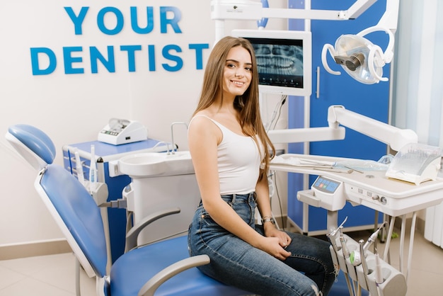 Photo jeune jolie femme dans une chaise de dentiste en attente de traitement