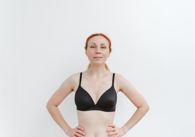 Une jeune jolie femme dans un soutien-gorge noir Superbe fille en sous-vêtements Santé du sein corps positif soins du corps mode de vie sain Studio fond blanc