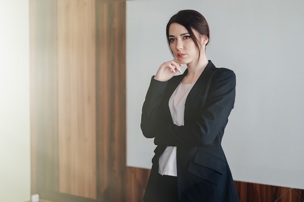 Jeune jolie femme émotionnelle dans des vêtements de style affaires