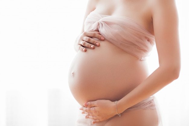 Jeune jolie femme enceinte à l'intérieur. Concept de maternité.